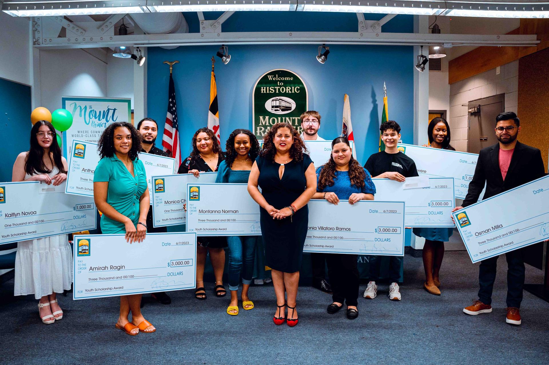 Ten recipients of the Youth Scholarship program pose with their award checks.